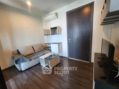 Modern living room with sleek furniture and wooden flooring, featuring a cozy sofa and wall-mounted shelves.