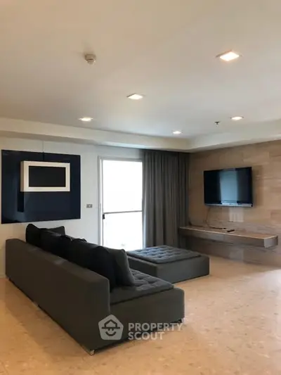 Modern living room with sleek furniture and wall-mounted TV in a stylish apartment.