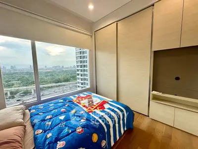 Modern bedroom with large window offering stunning city view and ample natural light.