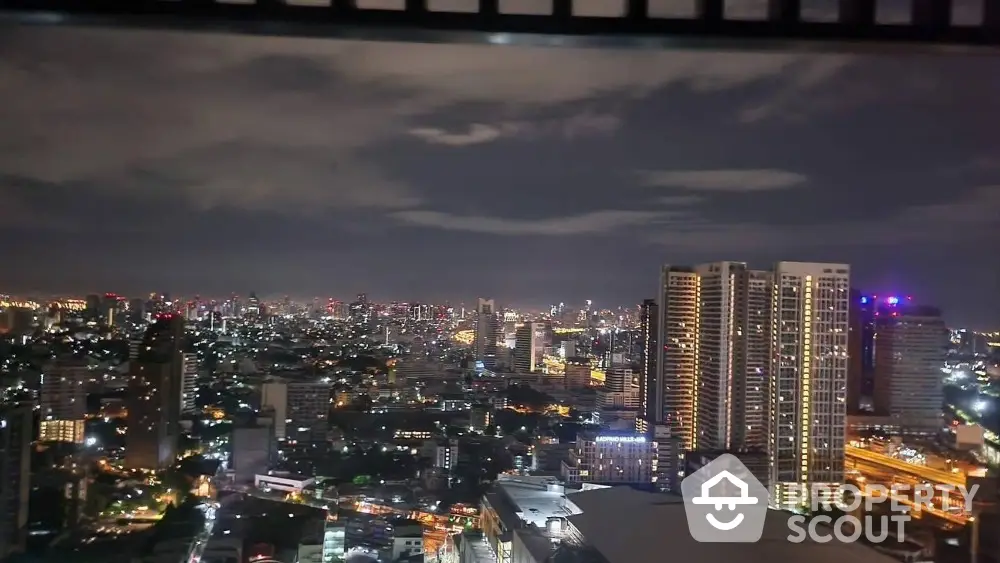 Stunning cityscape view from high-rise building at night with vibrant city lights.