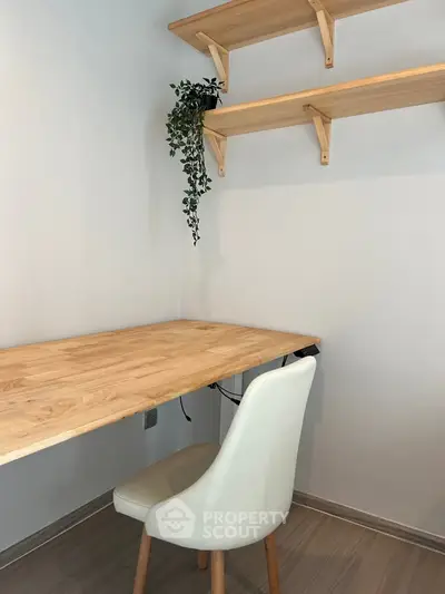 Minimalist study nook with wooden desk and shelves, perfect for a home office setup.