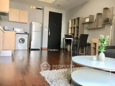 Modern apartment interior with wooden flooring, open kitchen, and stylish furniture.