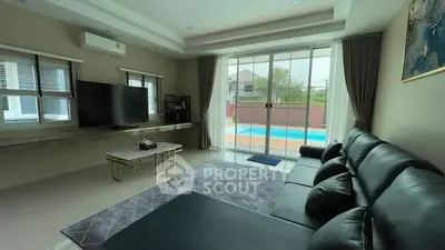Luxurious living room with pool view, modern furniture, and large windows for natural light.