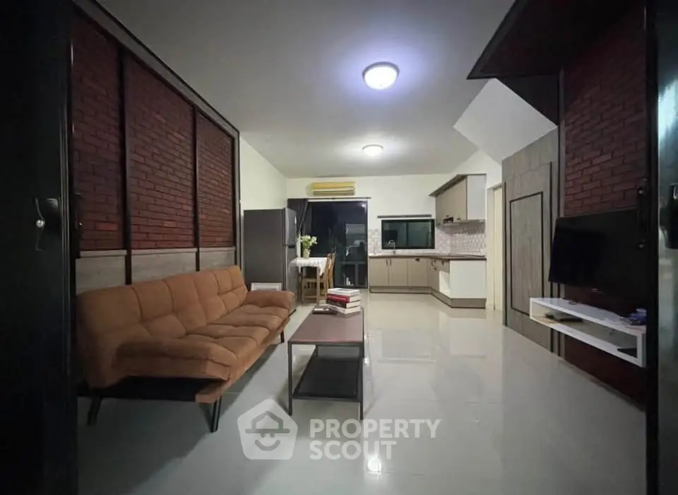 Modern living room with open kitchen and stylish brick wall design