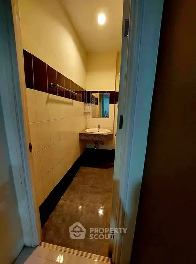 Compact bathroom with modern sink and tiled walls, ideal for efficient space use.