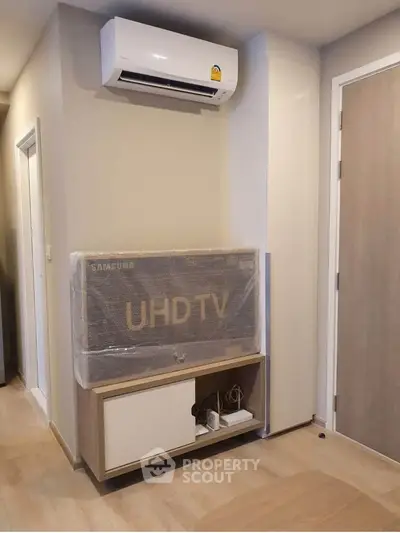 Modern living room with wall-mounted air conditioner and UHD TV setup.