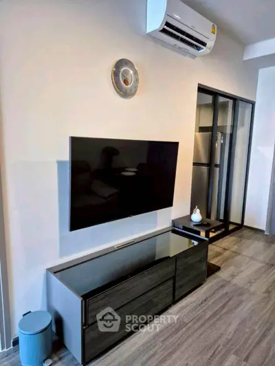 Modern living room with sleek TV unit and air conditioning, perfect for cozy relaxation.