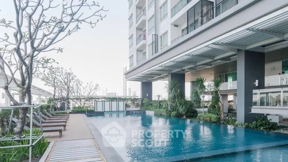 Luxurious apartment building with stunning pool and lush greenery, perfect for relaxation and leisure.