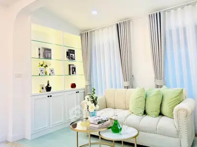 Elegant living room with plush sofa, stylish decor, and illuminated shelving.