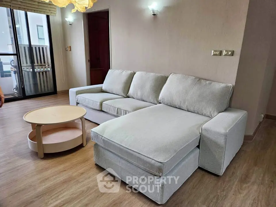 Spacious living room with modern sofa and wooden flooring, perfect for relaxation and entertaining.