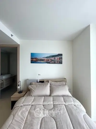 Modern bedroom with cozy bedding and wall art in a stylish apartment.