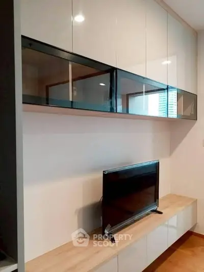 Modern living room with sleek wall-mounted cabinets and flat-screen TV