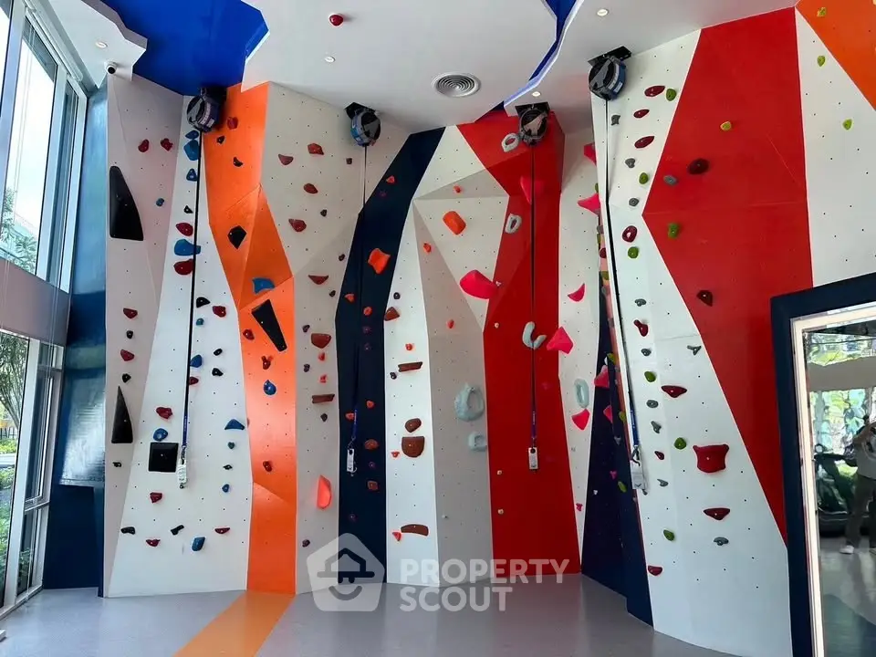 Modern indoor climbing wall in vibrant colors, perfect for fitness enthusiasts in a residential complex.