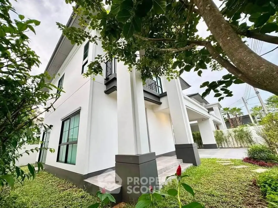 Elegant modern house exterior with lush garden and stylish architecture.