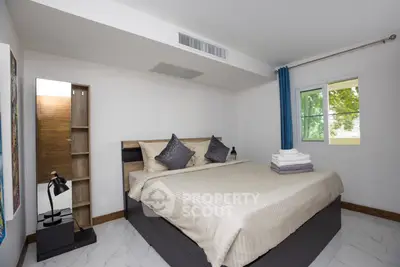 Modern bedroom with stylish decor and natural light in a cozy apartment.