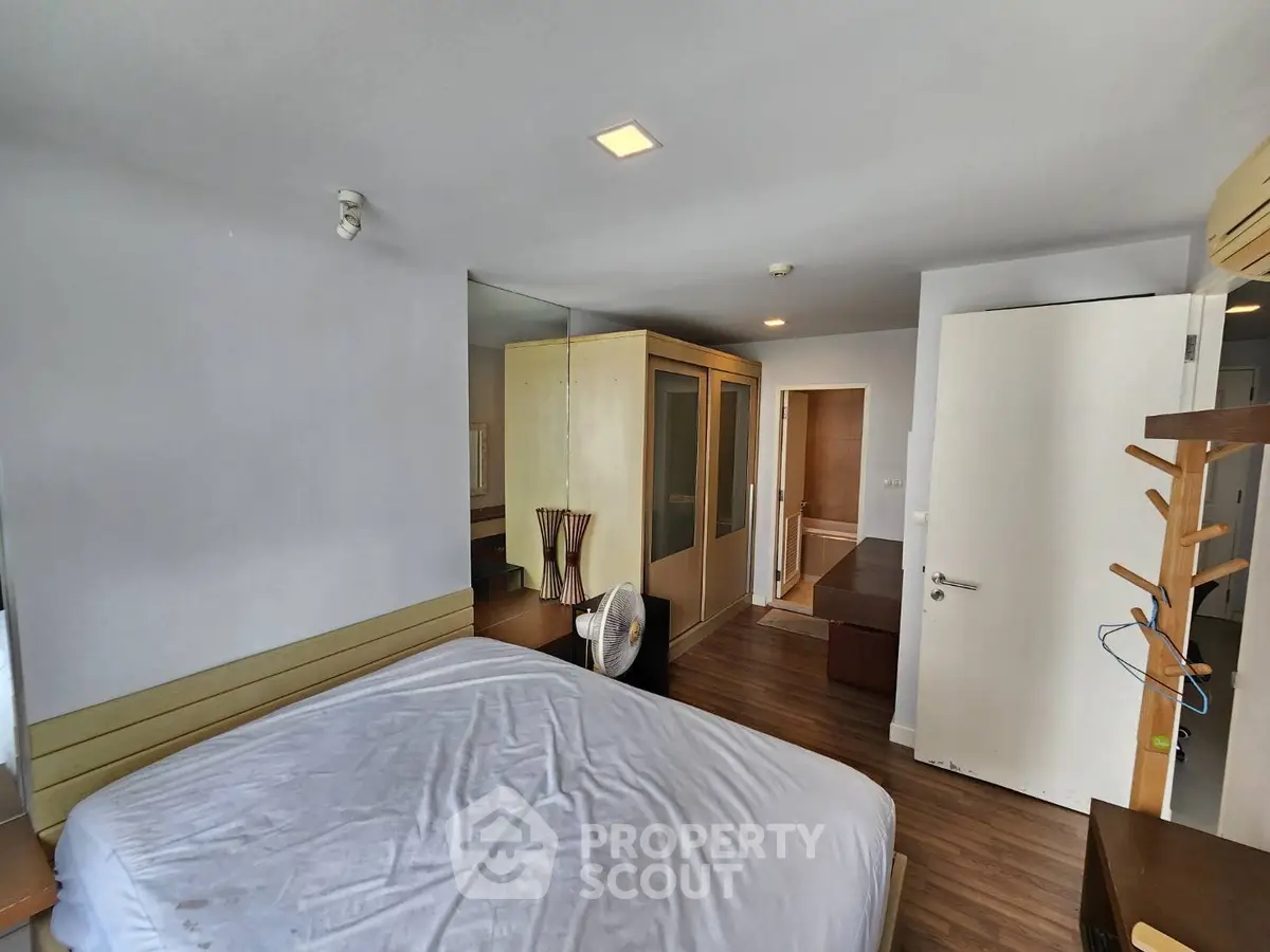 Spacious bedroom with modern furnishings and wooden flooring