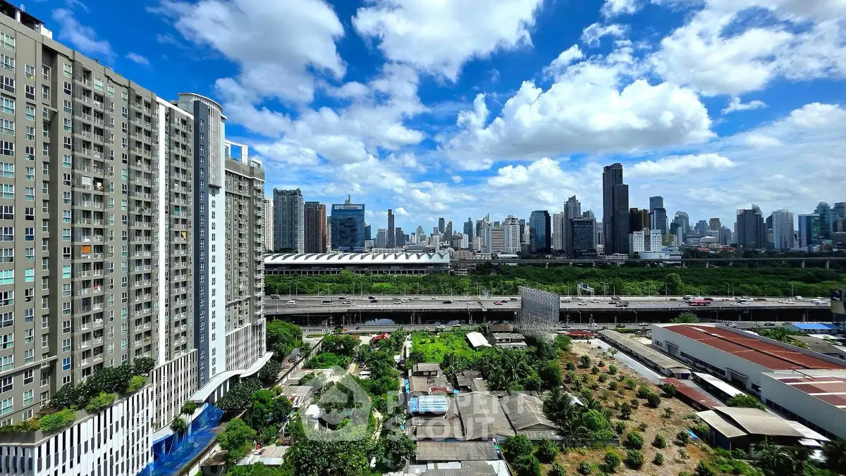 Stunning cityscape view from high-rise apartment with lush greenery and urban skyline.