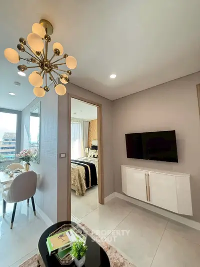 Modern apartment interior with stylish lighting and elegant decor, featuring a cozy dining area and a glimpse of the bedroom.