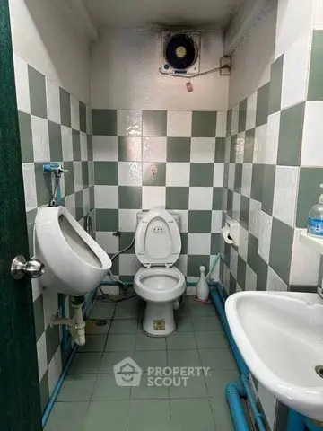 Compact bathroom with checkered tiles and essential fixtures, ideal for efficient space utilization.