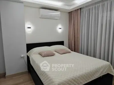 Modern bedroom with cozy lighting and air conditioning, featuring a comfortable bed and elegant curtains.