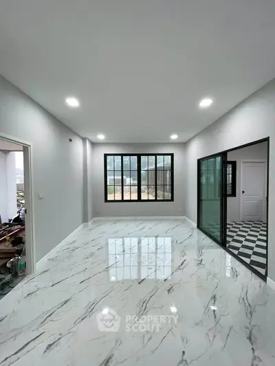 Spacious modern living room with marble flooring and large windows.