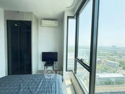 Modern bedroom with large windows offering stunning city views, featuring a sleek design and natural light.