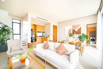 Spacious modern living room with open kitchen, stylish decor, and abundant natural light.