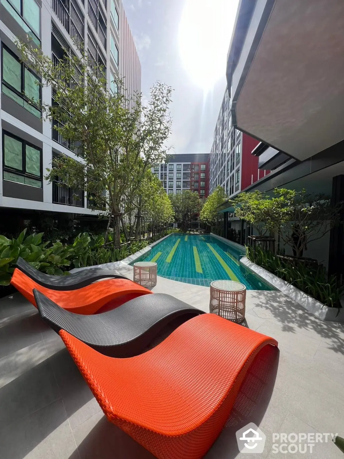 Modern apartment complex with stylish pool and vibrant lounge chairs