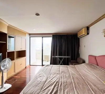 Spacious bedroom with balcony access and modern furnishings.