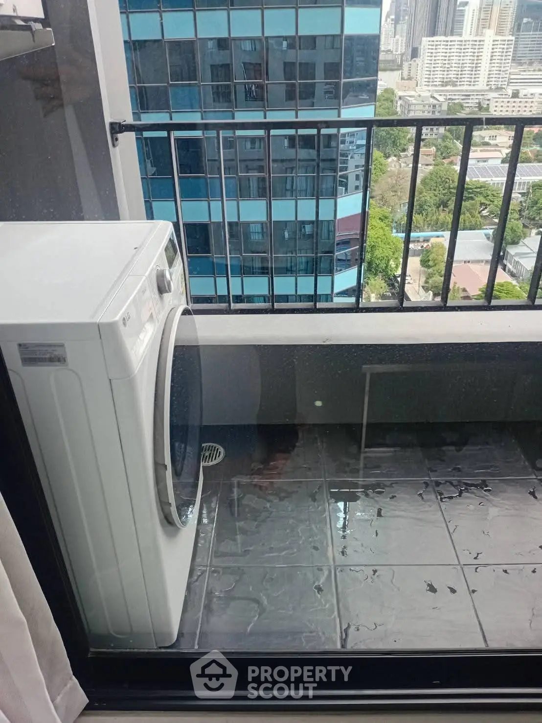 Modern balcony with washing machine and city view, perfect for urban living convenience.