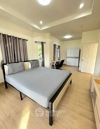 Spacious bedroom with modern furnishings and natural light, perfect for comfort and relaxation.