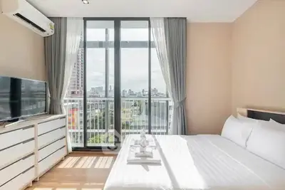 Bright and modern bedroom with city view and large windows in a stylish apartment.