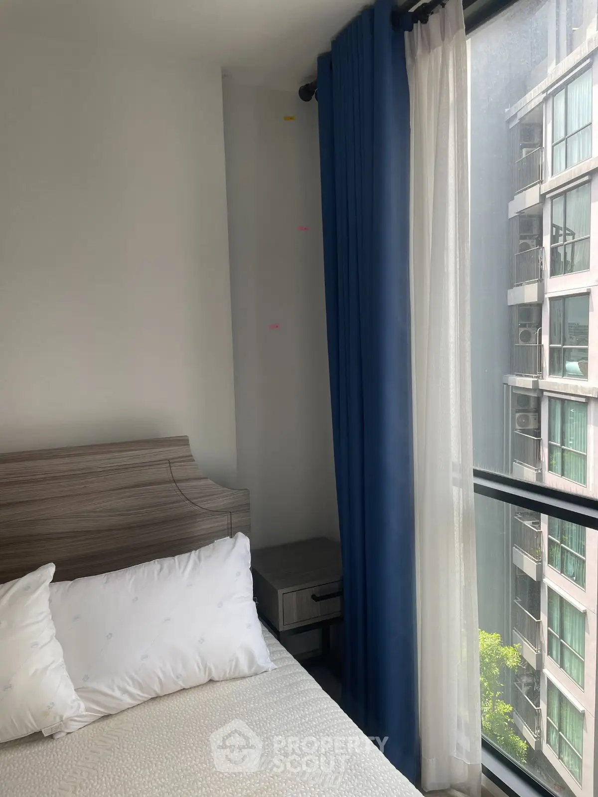 Cozy bedroom with modern decor and large window offering city view