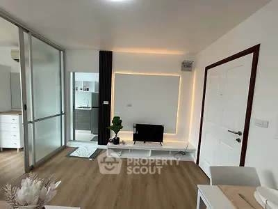 Modern living room with sleek design and ambient lighting, featuring a TV stand and sliding glass doors.