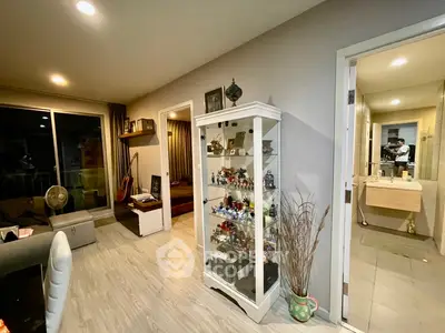 Spacious living area with elegant decor and open view to bedroom and bathroom.