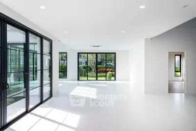 Spacious modern living room with large windows and garden view, perfect for natural light lovers.