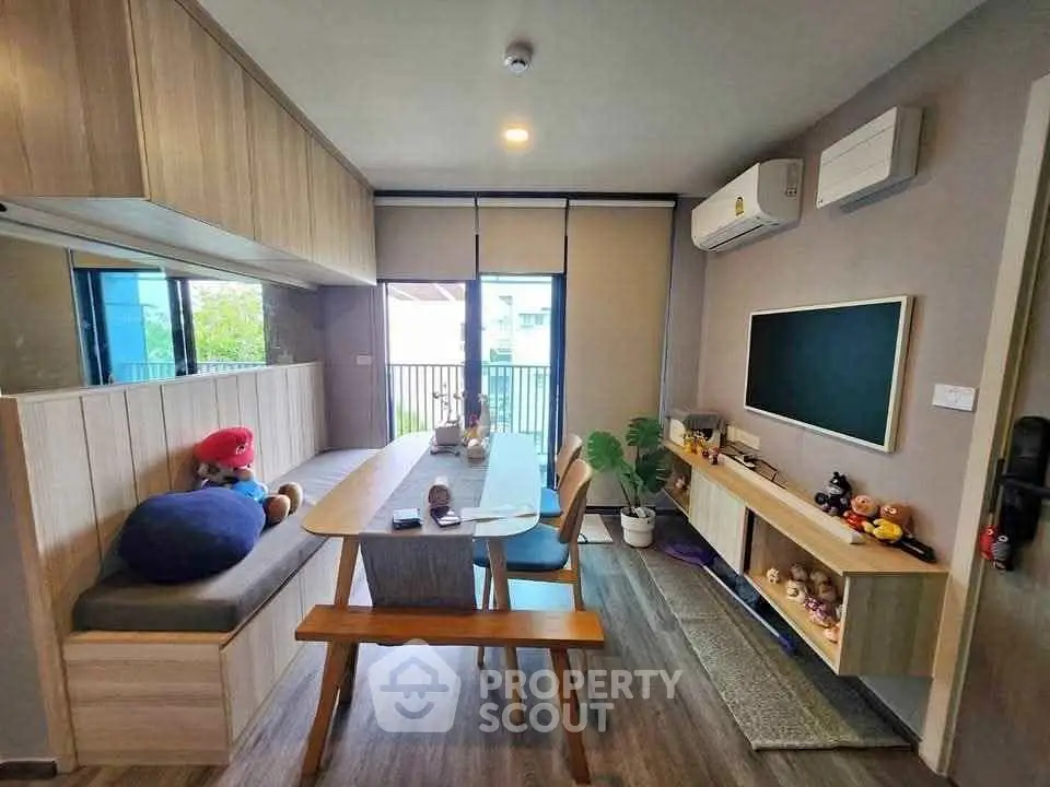 Modern living room with stylish furniture and natural light, featuring a cozy dining area and air conditioning.