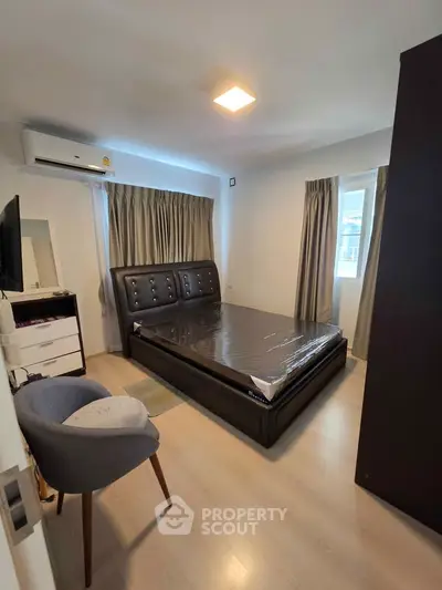 Modern bedroom with sleek furnishings and natural light, featuring a comfortable bed and stylish decor.