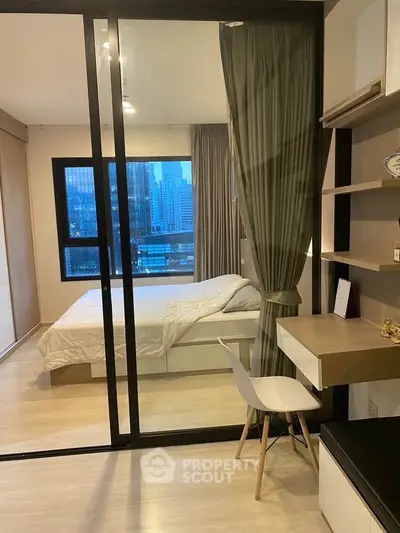 Modern bedroom with city view, featuring sleek furniture and a cozy workspace.