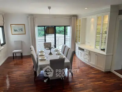 Elegant dining room with hardwood floors and large windows offering natural light.