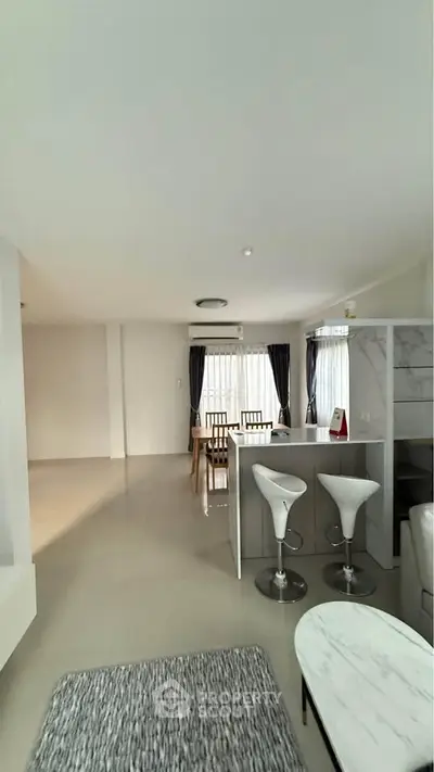 Spacious modern living room with open kitchen and stylish bar stools