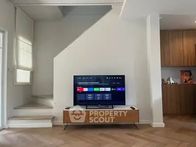 Modern living room with stylish TV setup and wooden accents, perfect for contemporary living.
