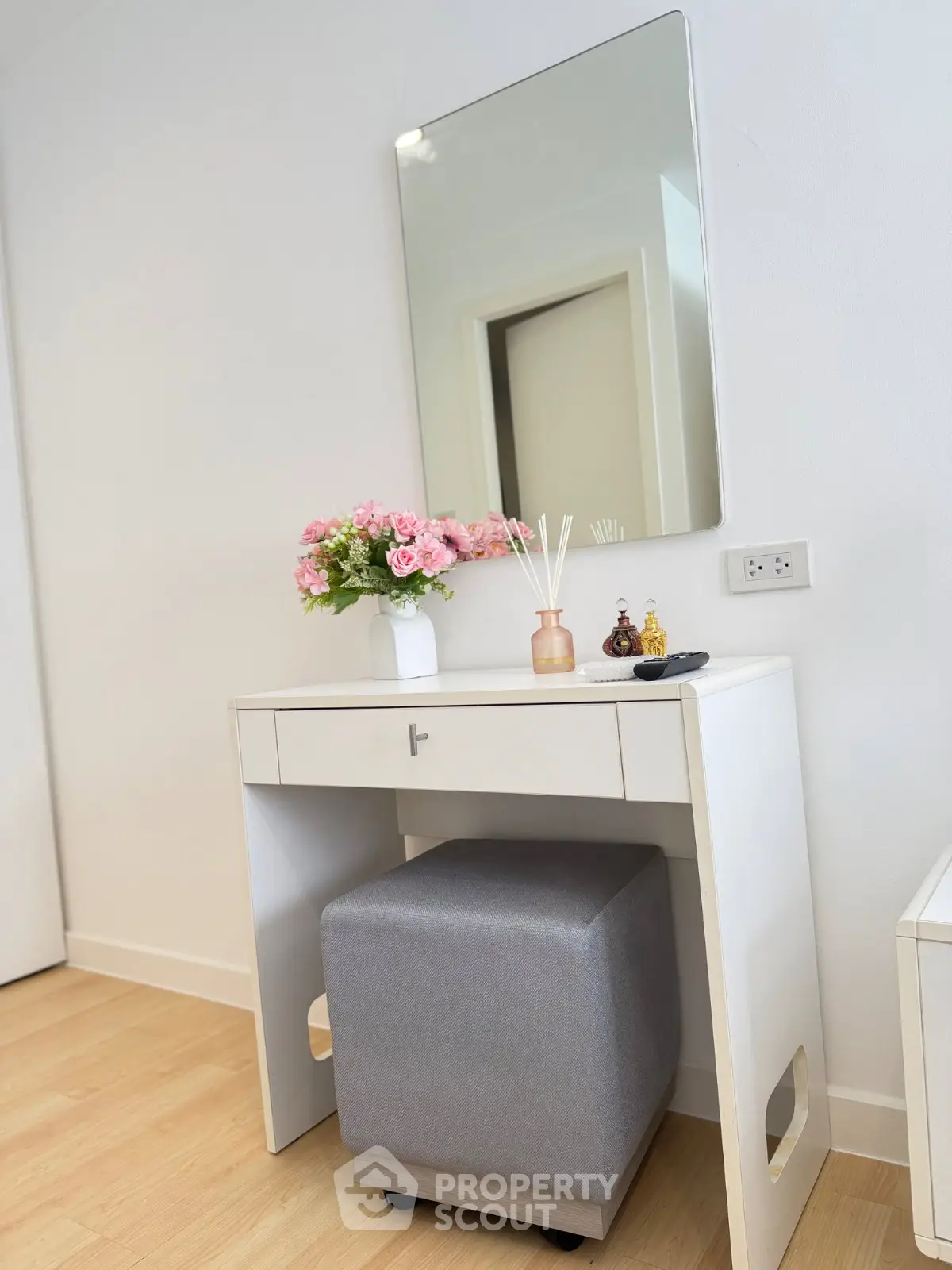 Elegant bedroom vanity with mirror and floral decor in modern apartment