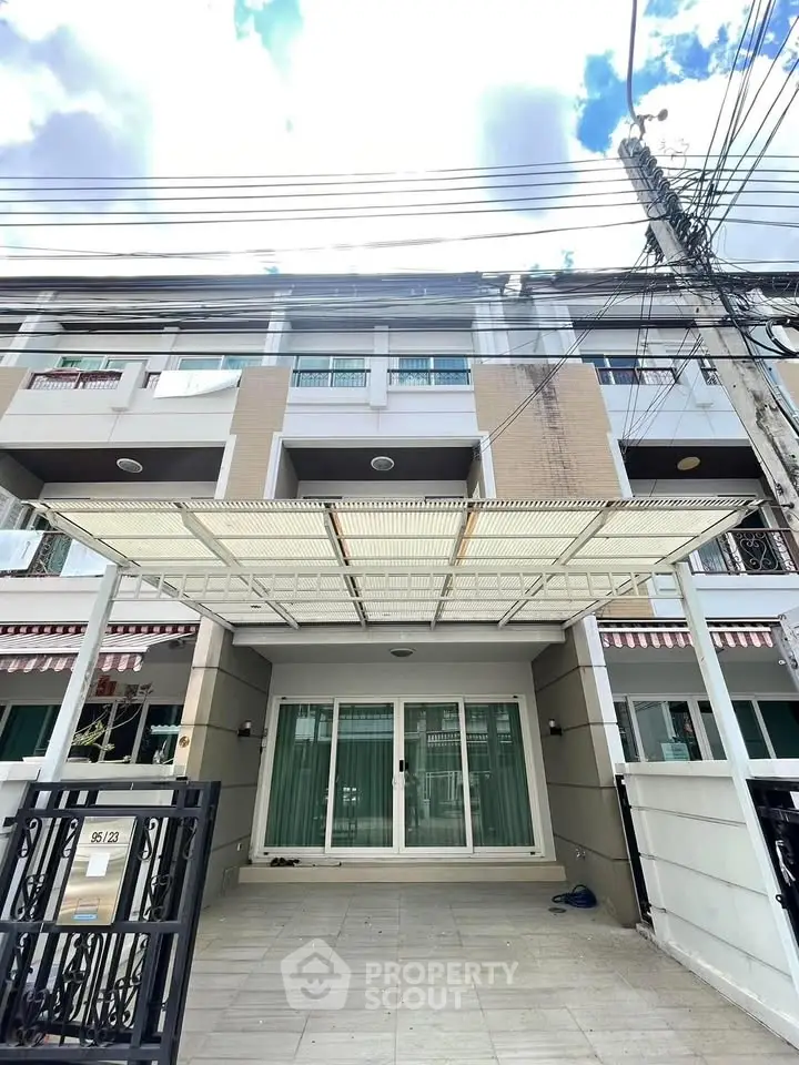 Modern townhouse exterior with covered parking and large windows