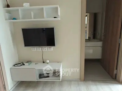 Modern living room with wall-mounted TV and open bathroom view