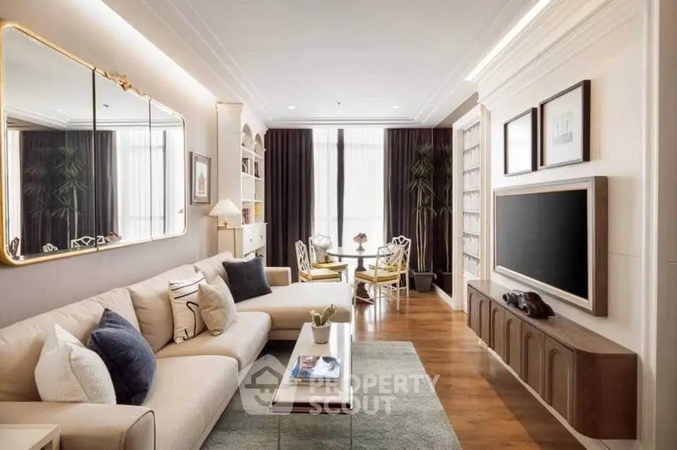 Luxurious living room with elegant decor, spacious seating, and large mirror enhancing natural light.