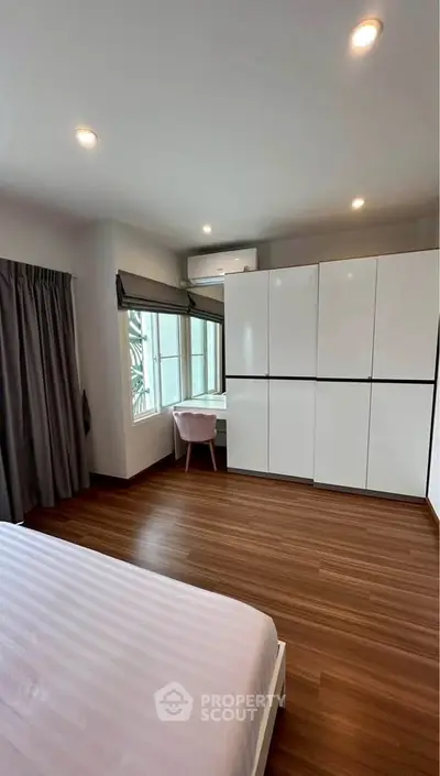 Spacious bedroom with modern wardrobe and natural light