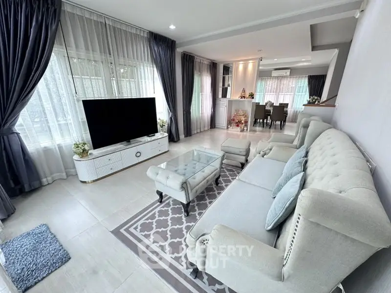 Elegant living room with plush seating and large windows, perfect for relaxation and entertainment.