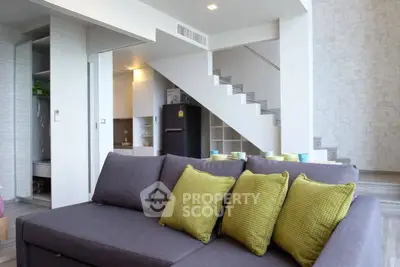 Modern living room with stylish staircase and cozy sofa in contemporary home