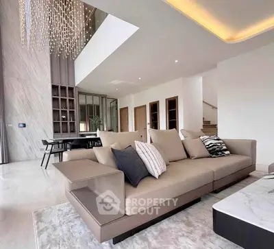 Luxurious modern living room with high ceilings and elegant chandelier